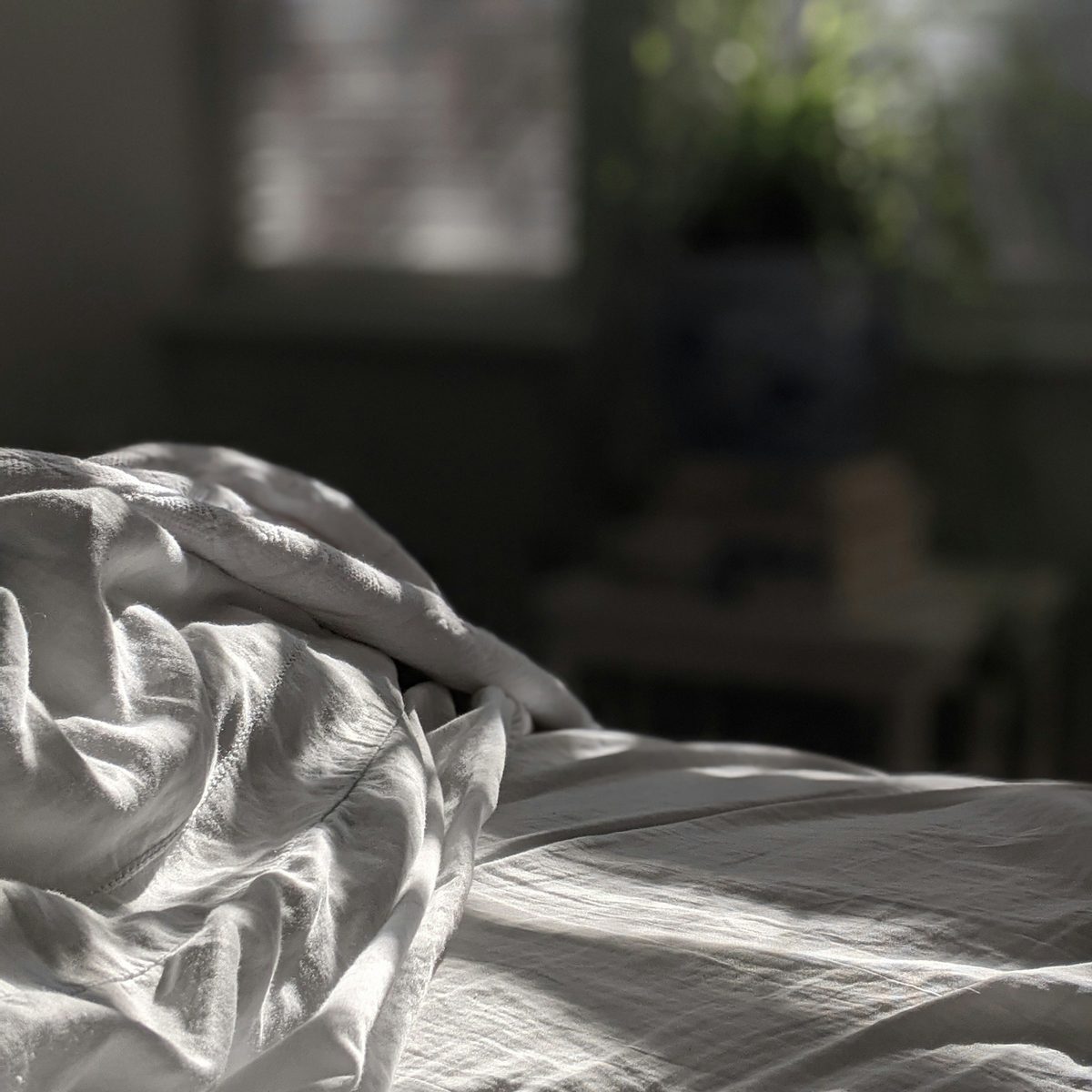 Édredon et linge de lit Linge de lit blanc et édredon sur un lit en bois