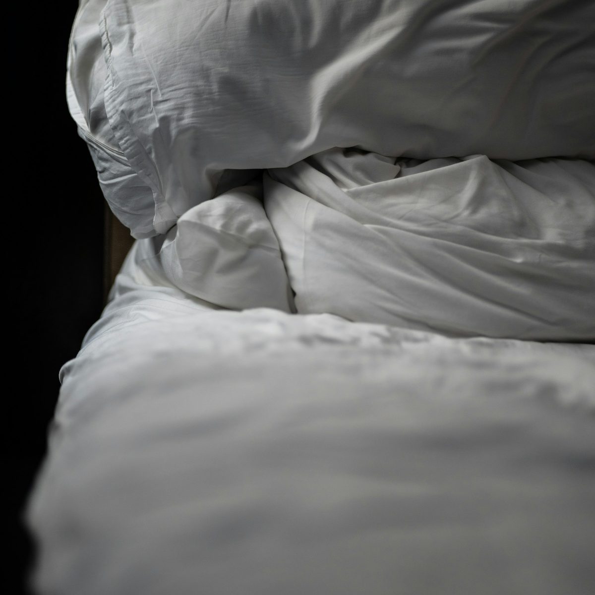 Oreiller garni de plumes Oreiller blanc garni de plumes sur un lit