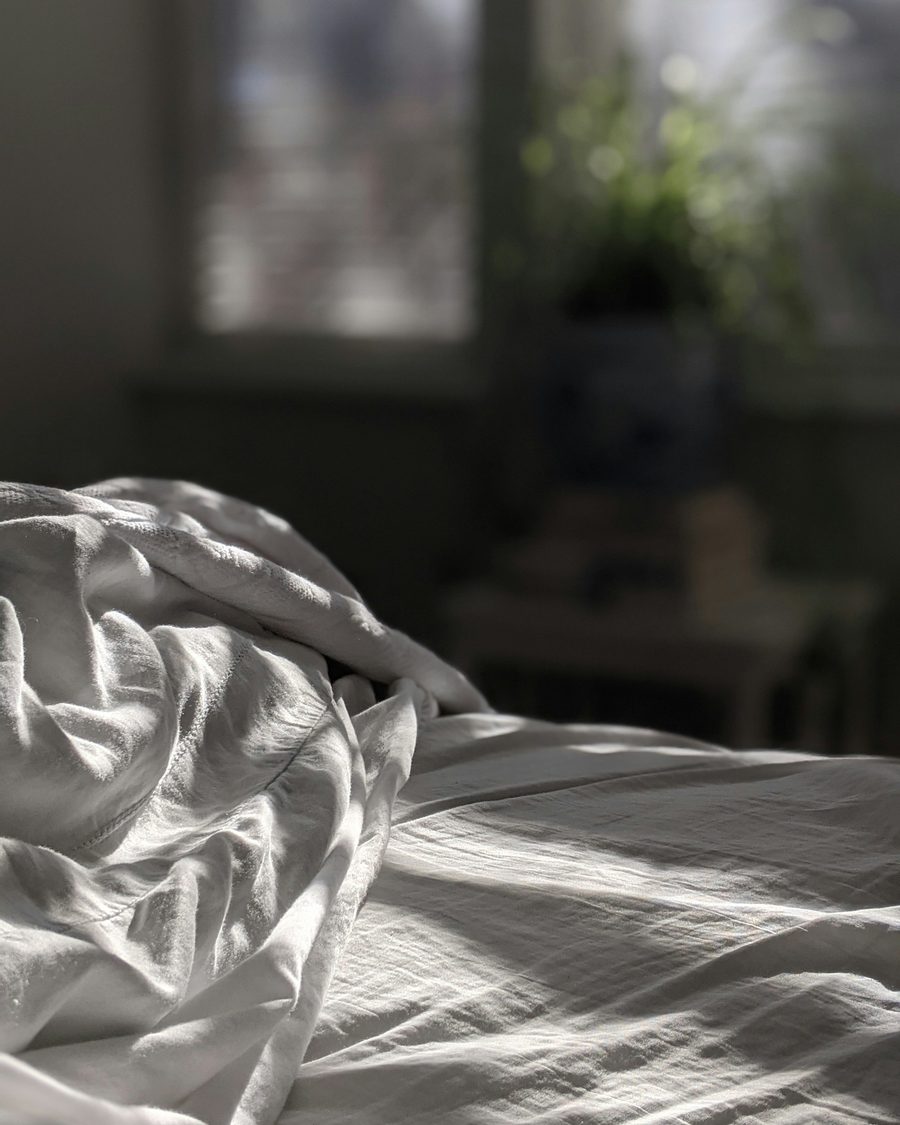 L'édredon Édredon blanc en duvet posé sur un lit en bois